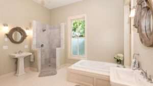 Badkamer met bad, douche, twee wastafels met spiegel en een raam