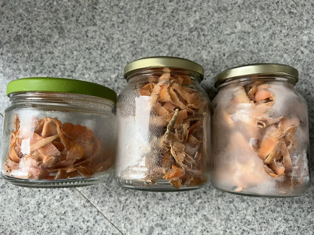 Restjes wortels ingevroren in hergebruikte glazen potjes om afval te verminderen